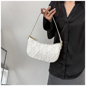 Detail view of the quilted white denim hobo bag with frayed fringe texture and handle