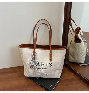 Detail of rainbow woven tote bag with PARIS MILANO print and star fringe charm
