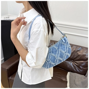 Detailed close-up of light blue denim shoulder bag featuring quilted rhombic textures