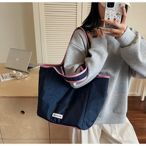 Großer marineblauer Shopper mit rosa Kontrastkante in einer Lifestyle-Büroumgebung gezeigt