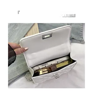 Detailed interior of white quilted chain bag showing capacity for phone and makeup