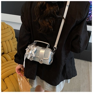 Détail d'un mini sac cylindre en jean et argent avec breloque étoile et fermoir métal