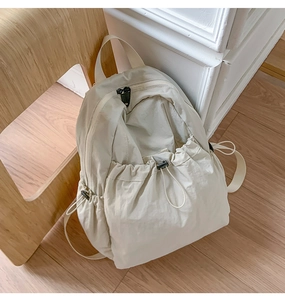 Close-up of beige drawstring backpack featuring nylon fabric and functional side pockets