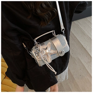 Gros plan du sac bandoulière argenté à paillettes avec breloques étoile et chien ballon