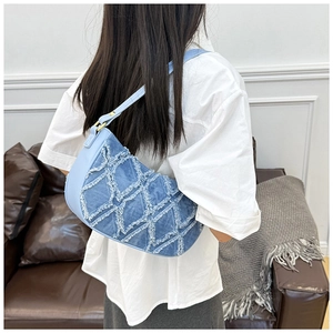 Vue détaillée du sac d'épaule en jean bleu avec motif à losanges effilochés et ferrures dorées