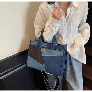 Detailansicht der Denim-Tasche mit Kontrastnähten und Goldschnalle am Modestil-Modell