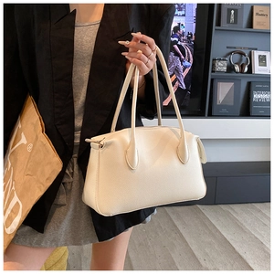 Dettaglio della borsa tote in pelle martellata color crema con manici sottili chic
