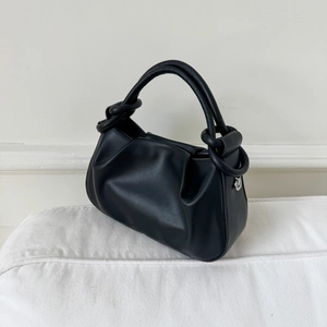 Detailed macro view of the black pleated cloud bag with soft leather and knotted handle