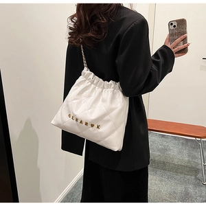 Detail of white quilted leather bucket bag with gold chain strap and metal logo