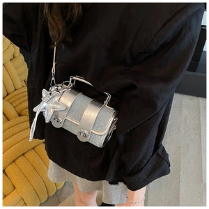 Détail du sac cylindre en métal argenté et denim avec breloque étoile sur mannequin