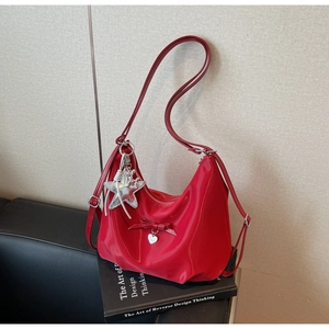 Macro view of red patent leather handbag with bow and silver star heart charm details