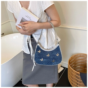 Borsa a spalla a mezzaluna in denim blu con decorazioni a farfalla e profili argentati