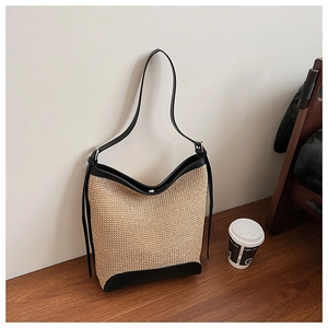 Texture détaillée du sac fourre-tout en paille tressée avec bordure et bandoulière en cuir