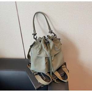 Detail of army green bucket bag with drawstring closure and metal hook hardware