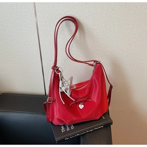 Detail of red nylon hobo bag with bow decoration and silver heart pendant charm