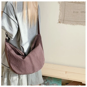 Detail der dunkelbraunen karierten Nylon-Umhängetasche mit verstellbarem Gurt und viel Platz