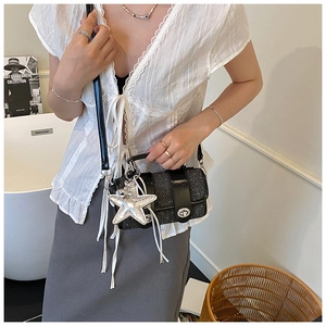 Détail du sac bandoulière noir texturé avec breloque étoile argentée et fermoir