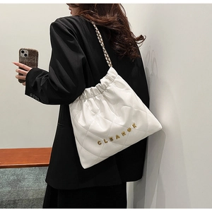 Detail of white quilted leather shoulder bag with gold logo and chain strap