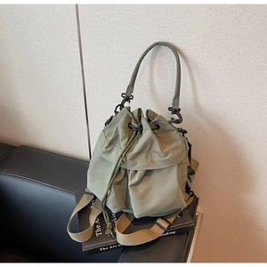 Detail of green drawstring bucket bag showing durable nylon fabric and woven straps