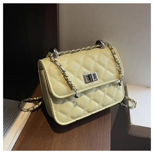 Detail of quilted leather pattern with silver chain strap and metal lock closure