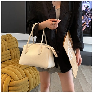Dettaglio della borsa a mano beige in pelle martellata con cerniera e doppi manici