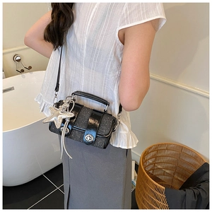 Détail du sac bandoulière noir pailleté avec pendentif étoile et fermoir métallique