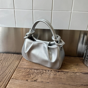 Detail of silver pleated cloud bag with metallic faux leather and knotted top handles