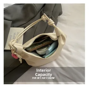 Interior espacioso del bolso dumpling beige con espacio para móvil y cosméticos