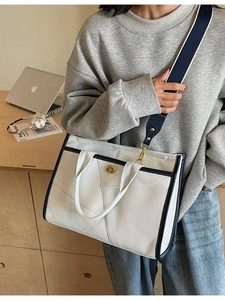 Große beige Canvas-Tragetasche mit dunkelblauem Rand und goldenem Verschluss für Alltag