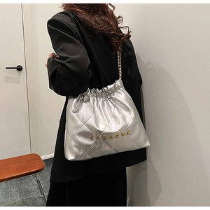 Detail of silver quilted bucket bag with gold chain strap and Clear K metallic logo