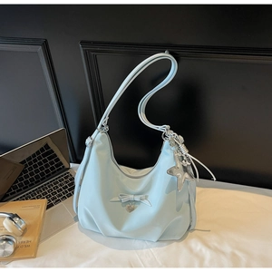 Close-up of light blue hobo bag with bow decoration and silver star metallic pendant
