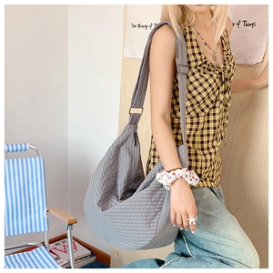 Detail der grauen Stepp-Hobo-Tasche aus Nylon mit verstellbarem Schultergurt am Model