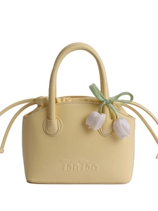 Pale yellow leather bucket bag with TonTon embossing and white tulip pendant accessories