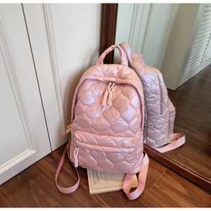 Pink quilted backpack in shiny waterproof nylon fabric featuring bubble rhombus texture