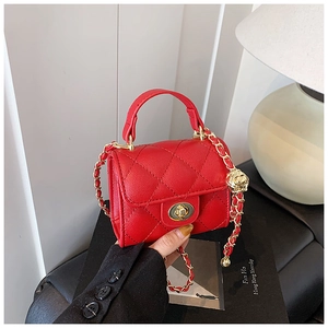 Detail of red quilted mini bag featuring lychee grain leather and golden chain strap