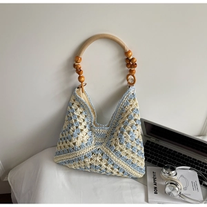 Macro detail of blue and white geometric crochet pattern with vintage wooden bead handle