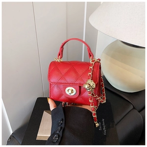 Detail of red quilted mini bag with lychee leather and gold sphere chain adjuster