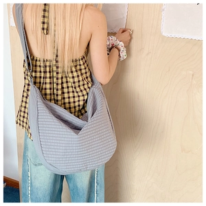 Detailansicht der grauen Karo-Nylontasche am Model zur Darstellung von Größe und Faltenwurf