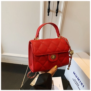 Detail of red quilted leather handbag with gold twist lock and chain strap