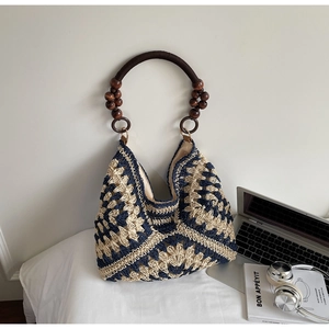 Detail of bohemian woven tote bag with geometric pattern and wooden bead handle