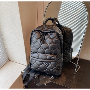 Detail shot of black quilted nylon backpack with rhombus pattern and smooth zippers