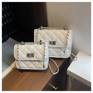 Detail view of white quilted chain bags in two sizes with silver metallic twist locks