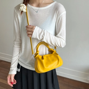 Detail showing bright yellow pleated cloud bag with metallic silver strap connectors