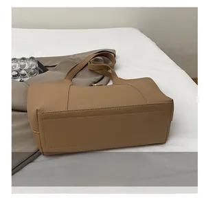 Detail showing the reinforced rectangular stitching on the durable litchi leather tote bag base