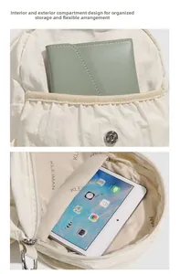 Détail du sac à dos en nylon crème avec plusieurs compartiments de rangement pour tablettes et portefeuilles