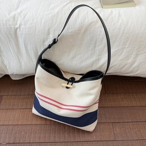 Detail of canvas tote bag with nautical stripes and wooden toggle closure