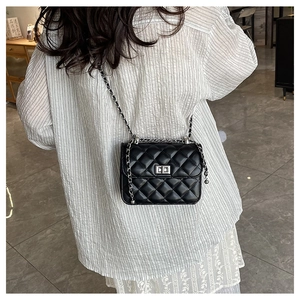 Close-up of black quilted chain bag featuring silver turn-lock and elegant metal strap