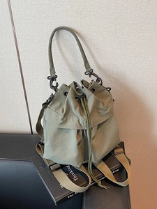 Olive green drawstring bucket bag with versatile hand and backpack straps for women
