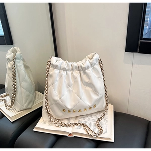 Detail of white quilted bucket bag with gold chain strap and CLEAR letter logo