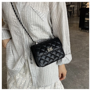 Detail of classic black quilted shoulder bag with silver twist lock and chain strap